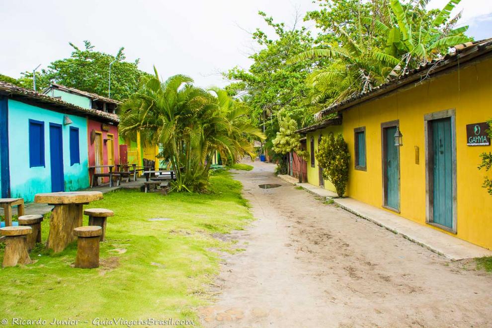 Imagem das ruas estreitas de areia e casas e comércio com suas fachadas bem coloridas no vilarejo em Caraiva.